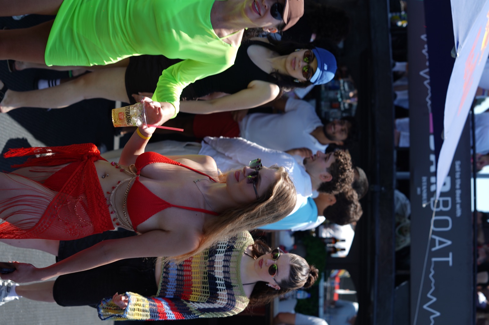 Guests in colorful swimwear on deck during the daytime swim boat party